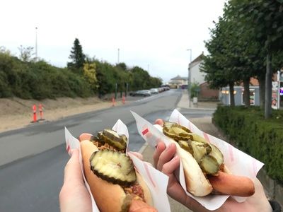 Struer, 12 September 2021 Hand holding hotdog on street in Struer