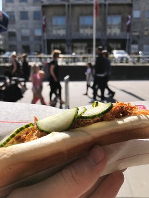 Aarhus Town Hall, 3 September 2017 Hand holding hotdog in front of Aarhus Town
Hall